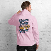 Person wearing a pink hoodie with colorful text on the back against a white brick wall.