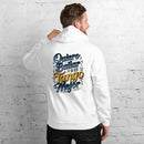 Man wearing a white hoodie with colorful text on the back against a white brick wall.