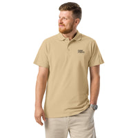 Man wearing a beige polo shirt with a logo on a white background