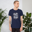 Man wearing a navy blue t-shirt with white text standing in front of plants.