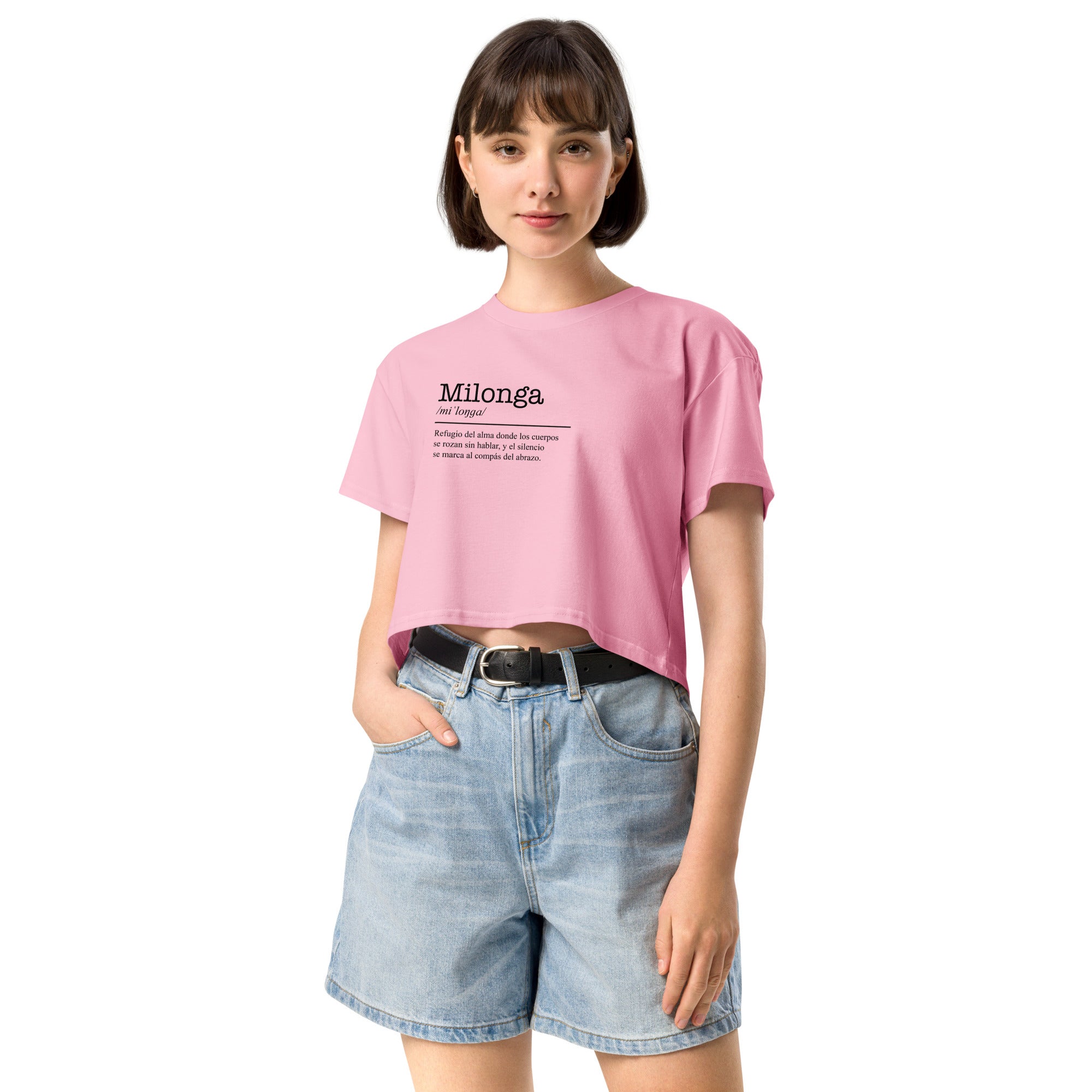 Person wearing a pink t-shirt with text and denim shorts on a white background