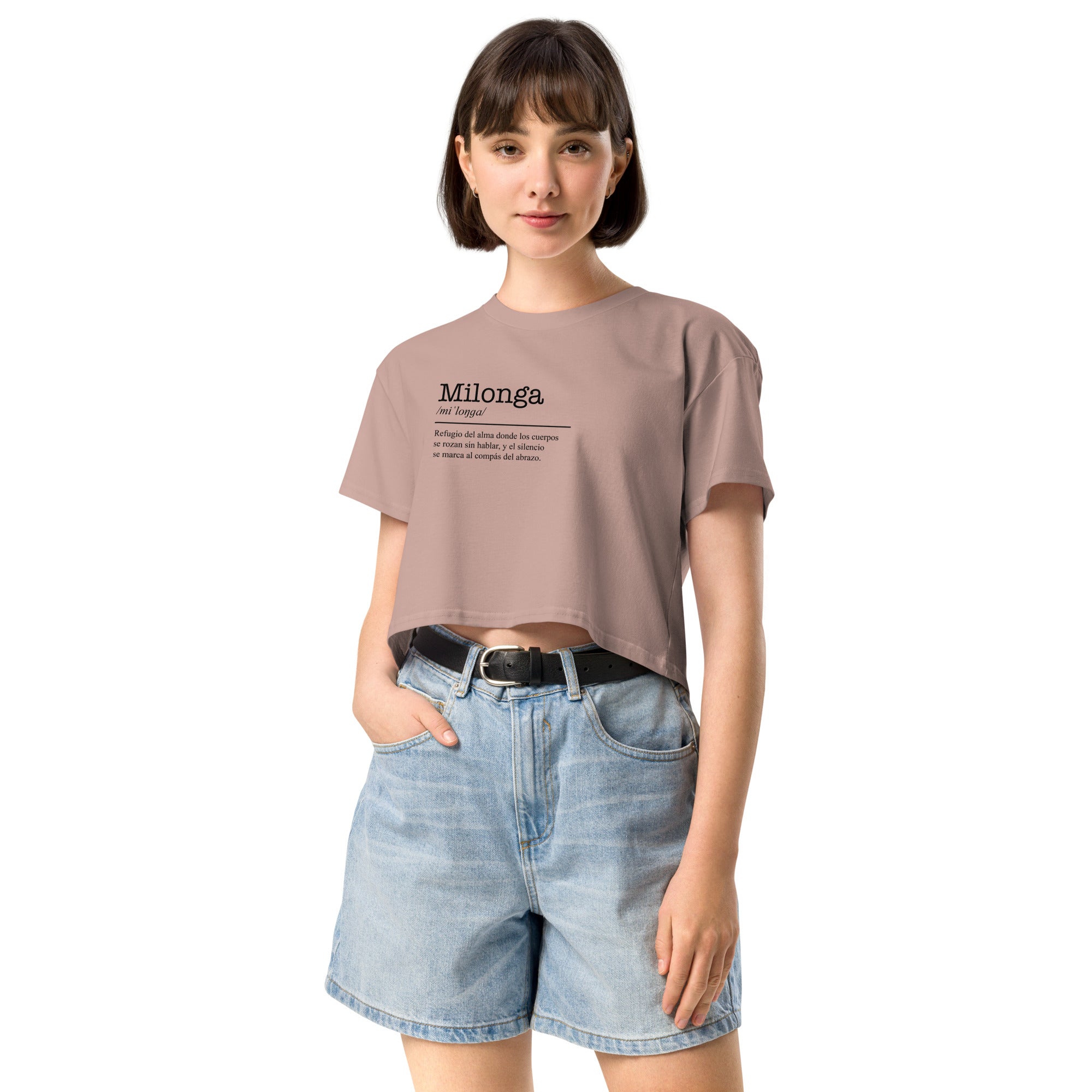 Woman wearing a beige t-shirt with text and denim shorts on a white background