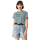Person wearing a light blue t-shirt with text and denim shorts on a white background