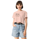 Woman wearing a pink t-shirt with text and denim shorts on a white background