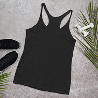 Black tank top on a gray surface with sneakers and dumbbells